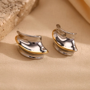 Detail of minimalist wave geometry earrings with two-tone gold and silver metallic finish