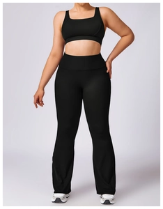Close-up of black plus size high-waisted flare yoga pants and sports bra set for women