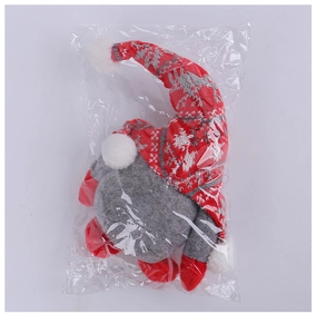 Close-up of a Christmas gnome plush in packaging with a red knitted hat and long beard