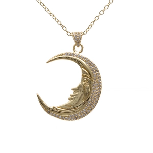 Gold crescent moon face pendant necklace with micro-paved zircons on white background