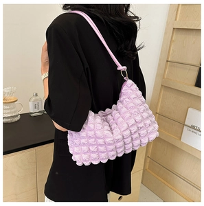Close-up of light purple bubble texture on a ruched shoulder bag worn by a model