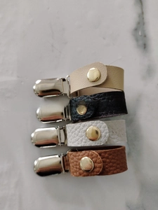 Detailansicht von Hut-Clips aus Leder in vier Farben mit Entenschnabel-Clips aus Metall