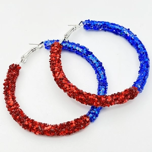 Detail of oversized hoop earrings with shiny red and blue sequins for sports fans