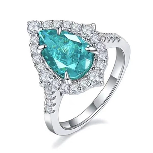 Luxury pear cut blue gemstone halo ring with pavé diamond band in white gold finish