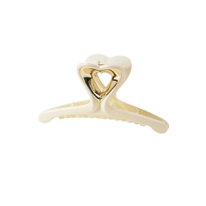 Detail of cream hair claw clip with golden hollow heart design and smooth finish