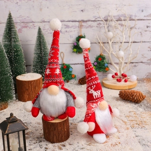 Standing Christmas gnomes in red and grey knit fabric on indoor snow scenery display