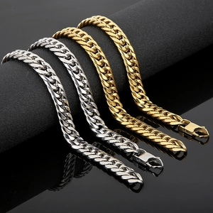 Detail of silver and gold Cuban link bracelets with lobster clasps on black display