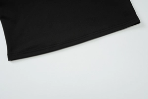 Détail des coutures à double aiguille de haute qualité sur l'ourlet du vêtement noir