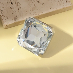Detail of a large square-cut crystal ring showing the claw setting and silver base