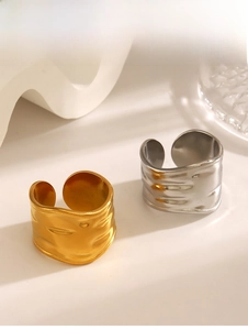 Detailed view of textured gold and silver irregular wide band rings with melted metal finish