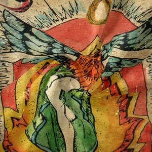 Macro shot of bohemian tapestry fabric showing vintage sun and wing illustration details