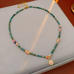Gros plan du fermoir en argent S925 sur un collier soleil vintage avec perles en pierre