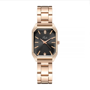 Detail shot of the rectangular black watch face with rose gold markers and steel band