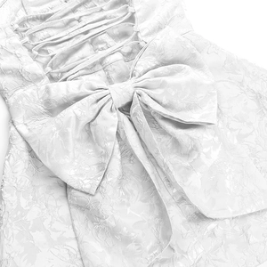 Détail du tissu jacquard blanc avec nœud au dos et design de laçage croisé