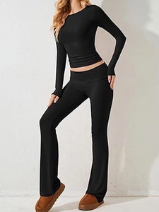 Dettaglio completo del set nero con crop top a maniche lunghe e pantaloni in maglia