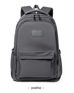 Front view of minimalist grey nylon backpack with large zipper pocket and padded straps