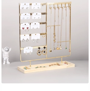Detail of wooden base jewelry organizer with gold hooks for earrings and necklaces