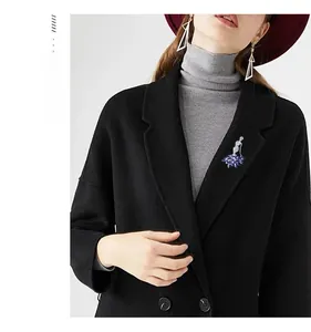 Close-up of ballet dancer brooch with blue crystals on a black wool coat lapel