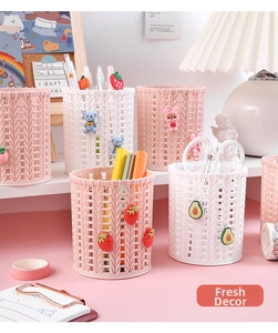 Pink and white woven desk organizers with cute cartoon charms in a study setup
