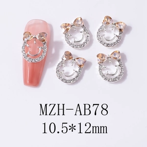 Macro view of crystal smile face nail charms with bowknot and rhinestone inlay