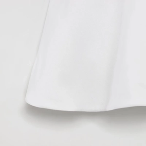 Macro detail of white twill fabric texture and hemline showing high-quality stitching