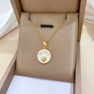Detailed macro view of the gold Mama necklace with enamel pendant in a jewelry box
