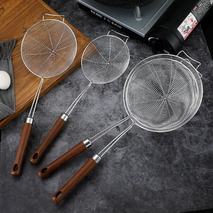 Set of 3 stainless steel skimmers with wood-pattern handles on a dark kitchen countertop