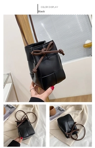 Detail view of black woven leather bucket bag with top drawstring and bow accent