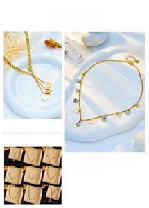 Detail of gold layered titanium steel necklaces with butterfly and evil eye pendants