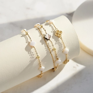 Pulsera de trébol dorada multicapa con colgantes de concha blanca y negra