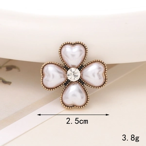 Macro shot of 2.5cm clover brooch with heart pearls and golden edge detail