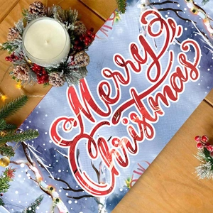 Blue Christmas table runner with red Merry Christmas text on a festive wooden surface