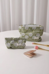 Detail view of cotton linen cosmetic bags with green fabric and white floral embroidery