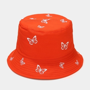Detailed view of white butterfly embroidery on vibrant orange cotton sun bucket hat