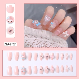 Detail view of pink press-on nails featuring My Melody 3D charms and pearl accents