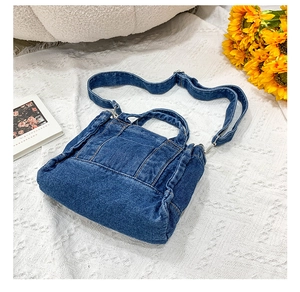 Detail of blue denim tote bag with adjustable strap and rustic flower decoration