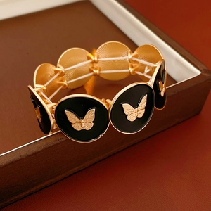 Macro shot of gold and black butterfly enamel bracelet with elastic inner band