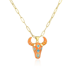 Macro shot of 18K gold plated bull head pendant with orange enamel and turquoise accents