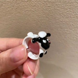 Close-up of cute black and white cartoon sheep ring with glossy enamel finish detail