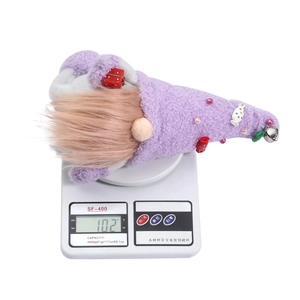 Detail view of purple Christmas gnome plush weighing 102g on a white scale