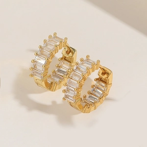 Detailed macro view of gold-plated huggie earrings set with rectangular zirconias