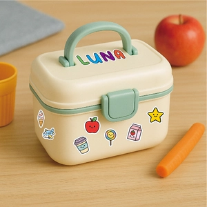 Detail of a creamy yellow lunch box with mint green handle and cute DIY cartoon stickers