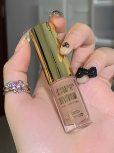 Close-up of shimmer liquid eyeshadow in nude pink with a stylish golden cap
