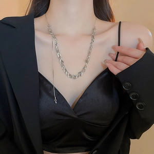 Dettaglio della collana argentata con paillettes e nappe di grano indossata da modella