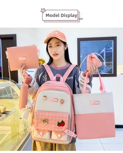 Detailed close-up of a 5-piece pink and white school backpack set with cute accessories