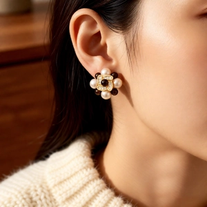Close-up of pearl flower earrings with rhinestones on a model in a warm setting