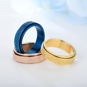 Nahaufnahme von mattierten Spinner-Ringen aus Edelstahl in Blau, Gold und Roségold