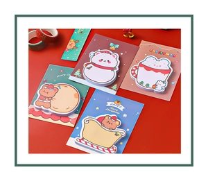 Detailed flat lay of four Christmas sticky notes featuring snowmen and bears