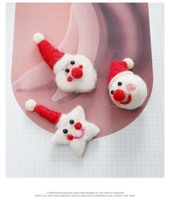Macro shot of handmade wool felt Santa Claus and star Christmas ornaments for DIY decor