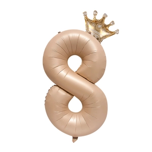Detail of a number 8 champagne gold foil balloon with a small golden crown decoration